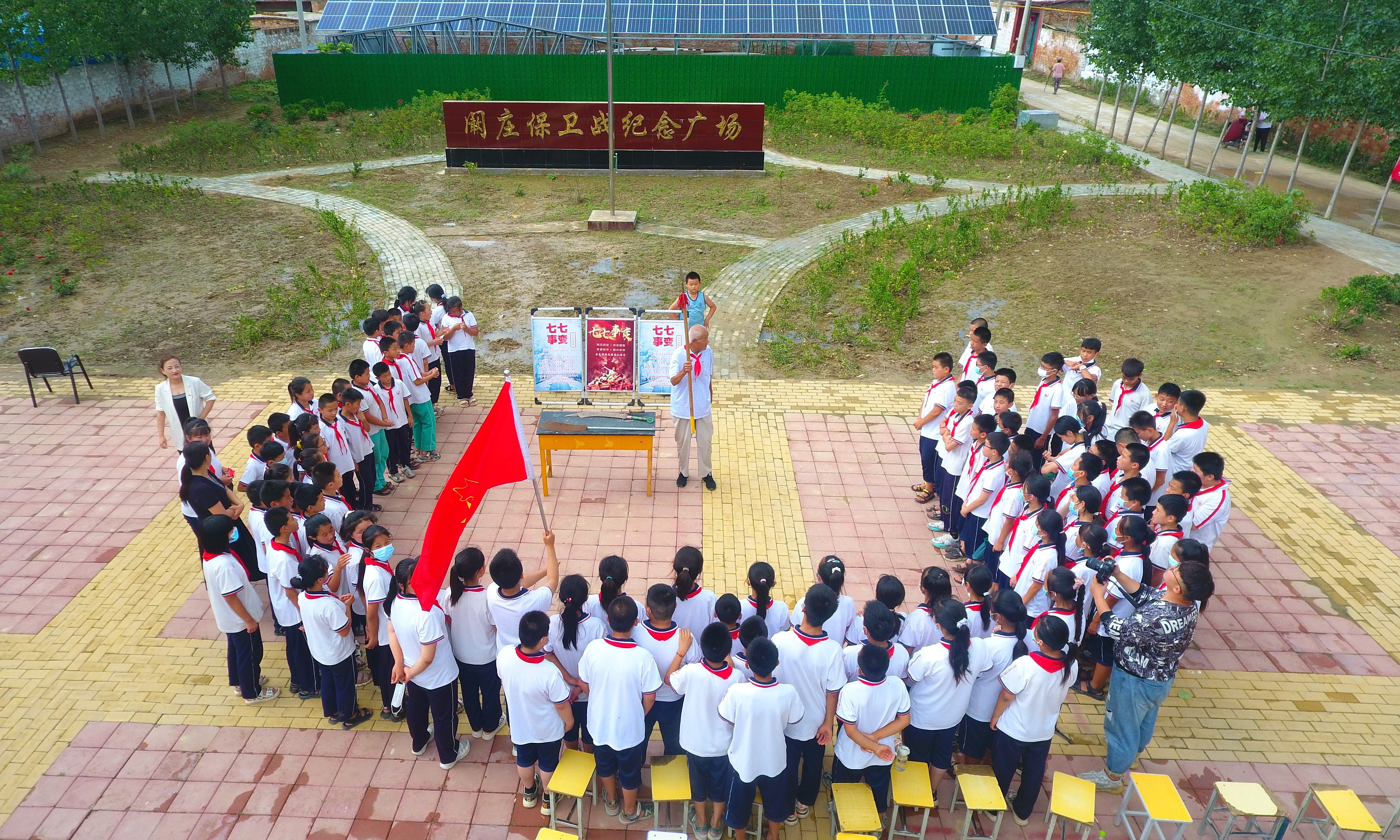 2022年7月6日，山東省聊城市，在茌平區(qū)菜屯鎮(zhèn)闞莊村的闞莊保衛(wèi)戰(zhàn)紀(jì)念廣場(chǎng)，闞莊保衛(wèi)戰(zhàn)親歷者王光木老人，為小學(xué)生們講述抗戰(zhàn)故事，展示大刀、長(zhǎng)矛。